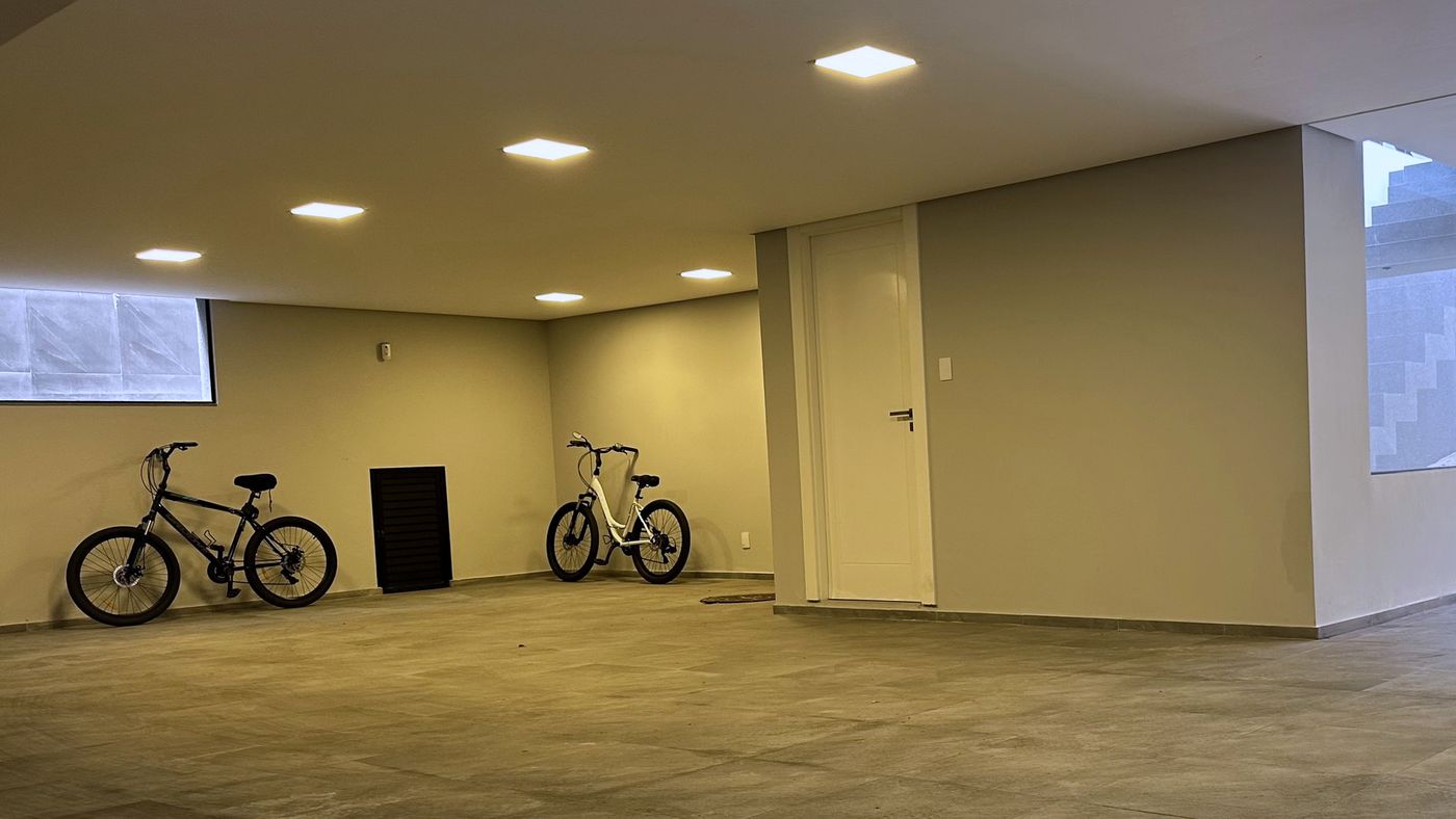 A garagem no subsolo, com 200 m² e duas bikes encostadas na parede
